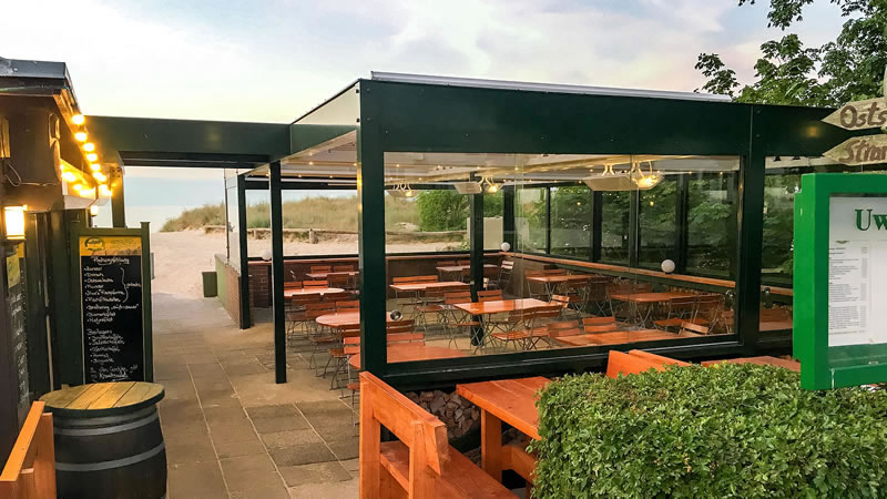 Detailansicht - Terrasse mit Lamellendach und seitlicher verschiebbarer Verglasung als  Wind- und Wetterschutz.