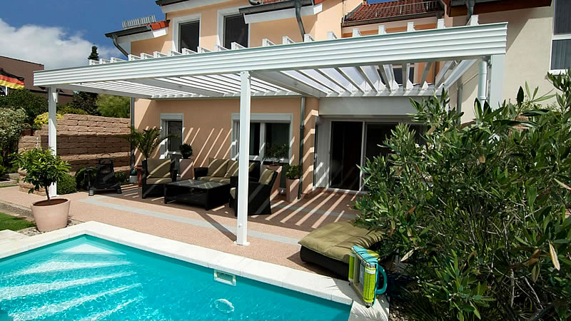 Lamellendach aus Aluminium passend zum mediterranen Stil des Hauses.