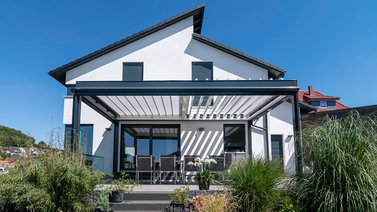 FLEDMEX® Classic Lamellendach aus Aluminium mit geschlossenen Lamellen auf moderner Terrasse in sommerlicher Umgebung.